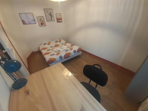 a small room with a bed and a table at Elise en plein coeur de la ville in Saint-Étienne