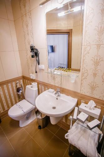 a bathroom with a sink and a toilet and a mirror at Aristokrat in Vinnytsya
