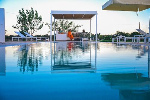 a swimming pool with blue water in a building at Masseria Luigi Flora in Ceglie Messapica