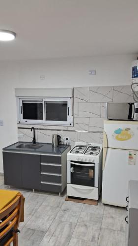 a kitchen with a stove and a refrigerator at Departamento Tunuyan in Monte Hermoso