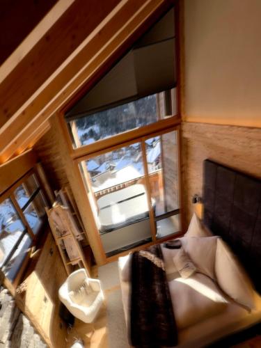 an overhead view of a bedroom with a large window at Boutique Lodge Spycher in Saas-Fee