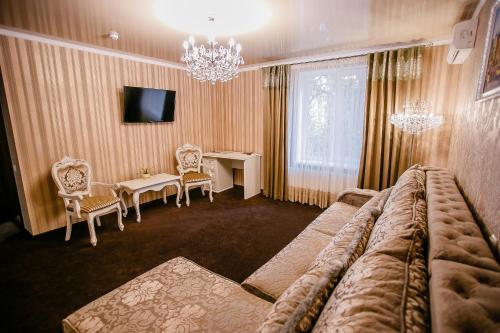 a living room with a couch and a table and a television at Aristokrat in Vinnytsya