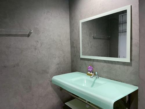a bathroom with a sink and a mirror at บ้านดาริน บีช Baan Darlin Beach in Phetchaburi