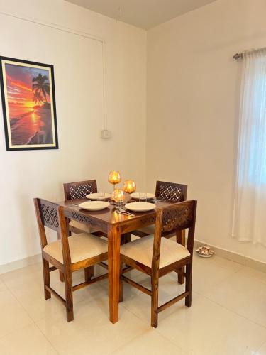 een eetkamer met een houten tafel en stoelen bij White House Stay in Patnem