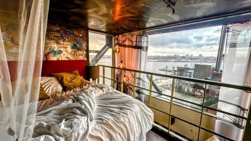 een slaapkamer met een bed en een raam op een schip bij Crane Hotel Faralda in Amsterdam