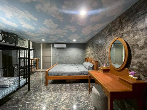 a bedroom with a bed and a mirror at บ้านดาริน บีช Baan Darlin Beach in Phetchaburi