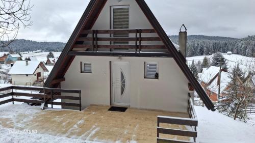 een huis met een dak met een deur in de sneeuw bij Vikendica Luka in Han Pijesak