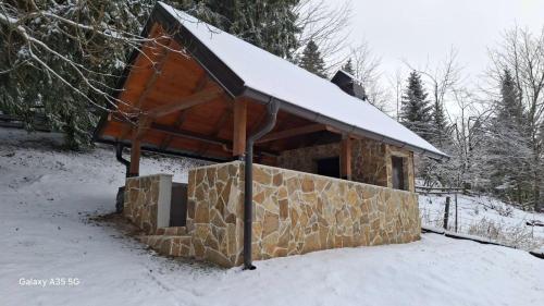 een gebouw met een met sneeuw bedekt dak in de sneeuw bij Vikendica Luka in Han Pijesak
