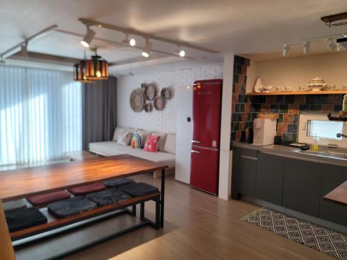 a kitchen with a table and a red refrigerator at Red Casa in Seogwipo