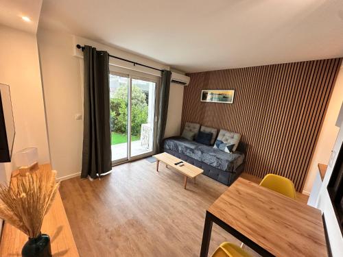 een woonkamer met een bank en een tafel bij Ocean et Golf in Anglet