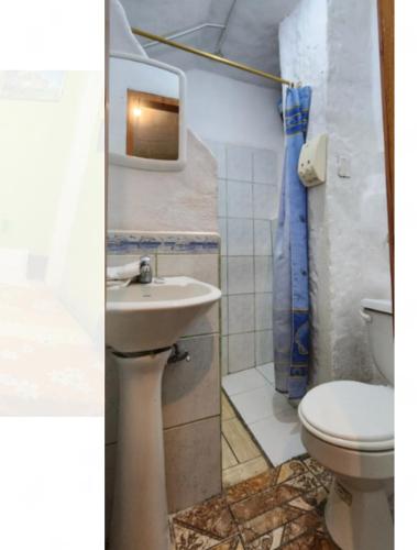 a bathroom with a sink and a toilet at Penguin Hostel in Puerto Ayora