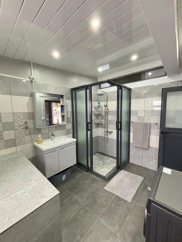 a large bathroom with a shower and a sink at Raj Adventures Hideaway - 7 Cascades in Vacoas