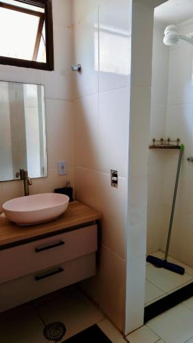 a bathroom with a sink and a mirror at Exelente Localiazação - 50m Enseada e Pitangueiras - Apt Saint Patrick in Guarujá