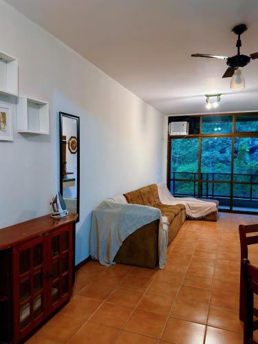 a living room with a couch and a mirror at Exelente Localiazação - 50m Enseada e Pitangueiras - Apt Saint Patrick in Guarujá