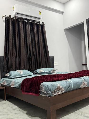 a bed in a room with a curtain at Hotel Sarkar in Indore