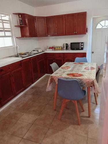 una cucina con tavolo e sedie e una cucina con lavello di Cassiane apartments a Thibaud