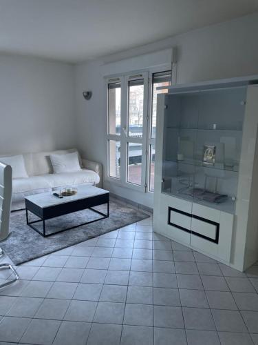 a living room with a couch and a coffee table at Appartement 6 personnes avec jacuzzi in Torcy