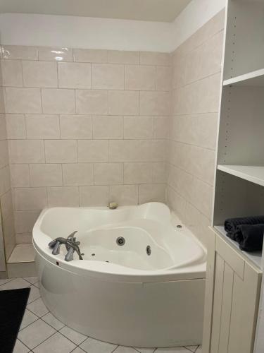 a white bath tub with a spider sitting on top of it at Appartement 6 personnes avec jacuzzi in Torcy