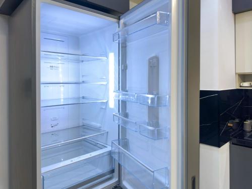 een lege koelkast met de deur open in een keuken bij Toshkent city apartments in Tasjkent