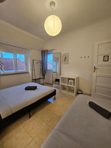 a bedroom with two beds and a large window at spacious guest rooms in Lisbon