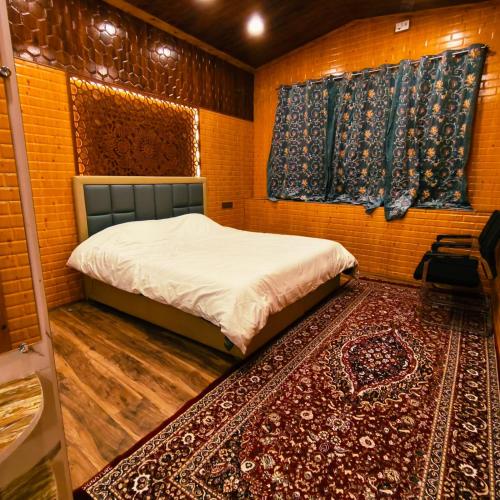 a bed in a room with a rug and two windows at Id villa cottage in Tangmarg