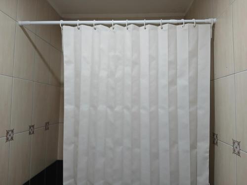 a shower with a white shower curtain in a bathroom at Apartman Lada in Bijeljina