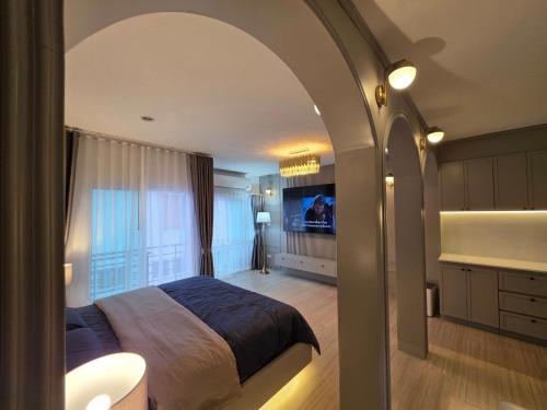 a bedroom with a bed and a tv in it at Rarin jinda RESIDENCE in Suratthani