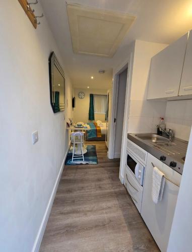 a small kitchen with a sink and a stove at The Cosy Pod Studio - Short Stay in Salford in Manchester