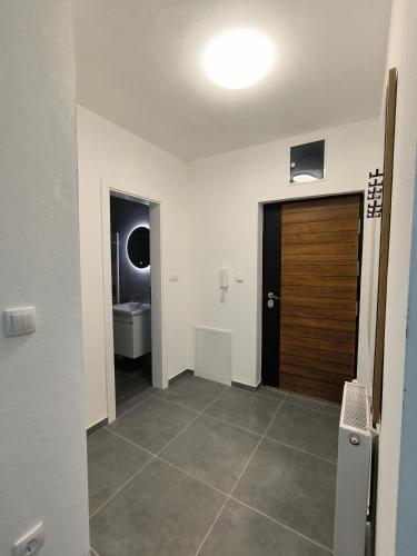 un corridoio con porta in legno e un bagno di Apartman Prijedor a Prijedor