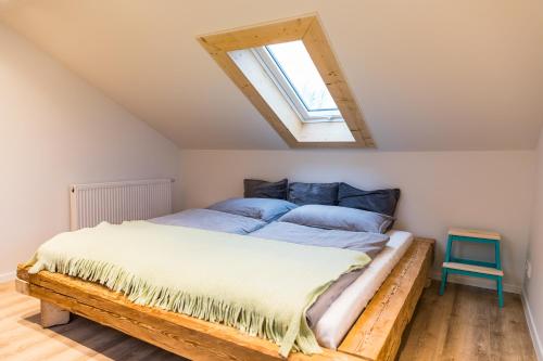 a bedroom with a large bed with a skylight at Ferienhaus am Eichberg in Grabenstätt