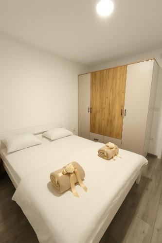 2 asciugamani su un letto bianco in una camera di Apartman Prijedor a Prijedor
