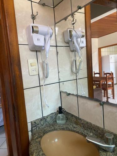 a bathroom with a sink and a hair dryer at Apartamento Day in Ilhéus