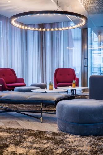 a living room with red chairs and a couch at Radisson Blu Hotel Tromsø in Tromsø