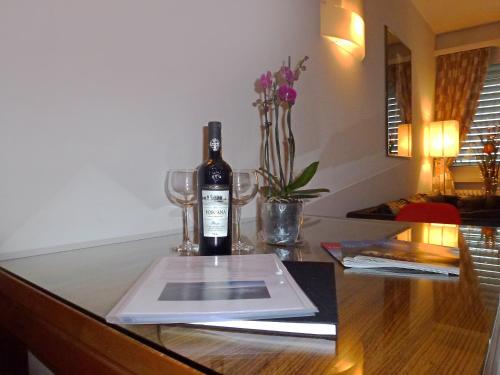 una bottiglia di vino seduta su un tavolo con bicchieri di Panorama Studio Apartment a Castagnola