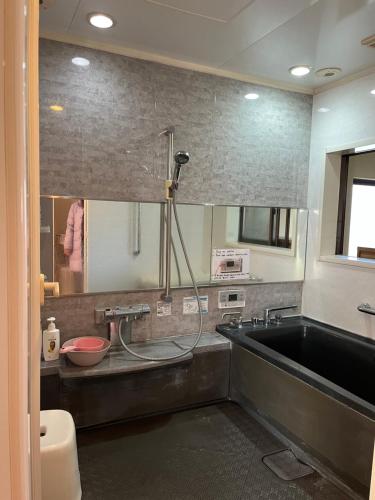ein Badezimmer mit Waschbecken und Badewanne in der Unterkunft Kamida179 in Oguni