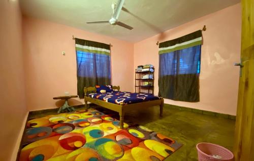 a bedroom with a bed with a colorful rug at HIGSAM apartment in Diani Beach