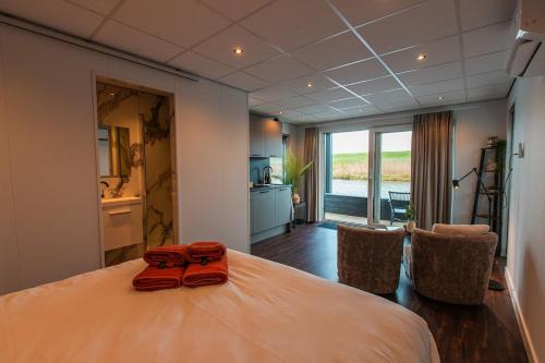 a bedroom with a bed with two red towels on it at Tiny Boat House #5 in Garnwerd