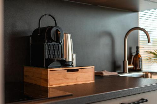 a kitchen counter with a sink and a box with a speaker at Tiny Boat House #5 in Garnwerd