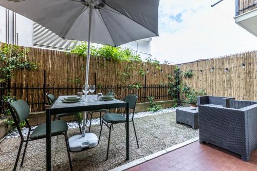 een tafel en stoelen met een parasol op een terras bij Casa Beatrice in Albinia