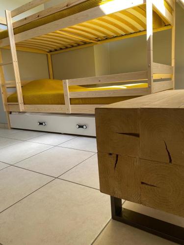 a room with two bunk beds with yellow sheets at Residentie Sofie in Koksijde