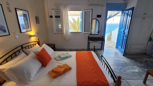 a bedroom with a bed with an orange blanket at Akrogiali studios in Donoussa