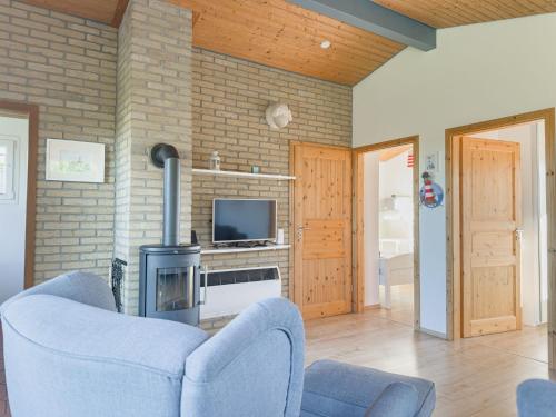 a living room with a blue chair and a fireplace at Lundenbergsand in Simonsberg
