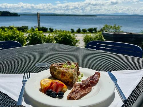 einen Teller mit Fleisch und Obst auf dem Tisch in der Unterkunft North Hero House Inn and Resort in North Hero