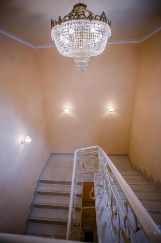 a staircase with a chandelier in a room at Aristokrat in Vinnytsya