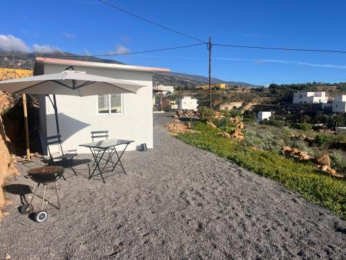 a table with an umbrella next to a building at Casa rinconcito de Arico in Los Gavilanes