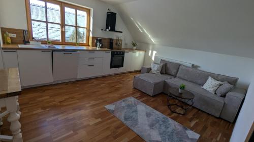 a living room with a couch and a kitchen at NEU Apartment Antonia - Ferienglück Allgäu in Lachen