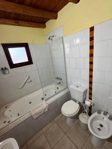 a bathroom with a toilet and a tub and a sink at Terrazas de Colón in Colón
