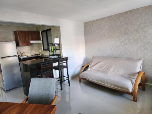 a kitchen with a couch and a table in a room at Apartment with a lagoon view in Cancún