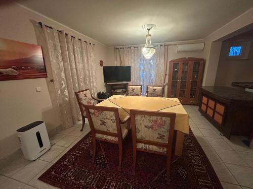 una sala da pranzo con tavolo, sedie e televisione di Stara Ruža a Gračanica