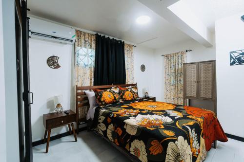 a bedroom with a bed with a colorful comforter at Aintree Bungalow in Portmore